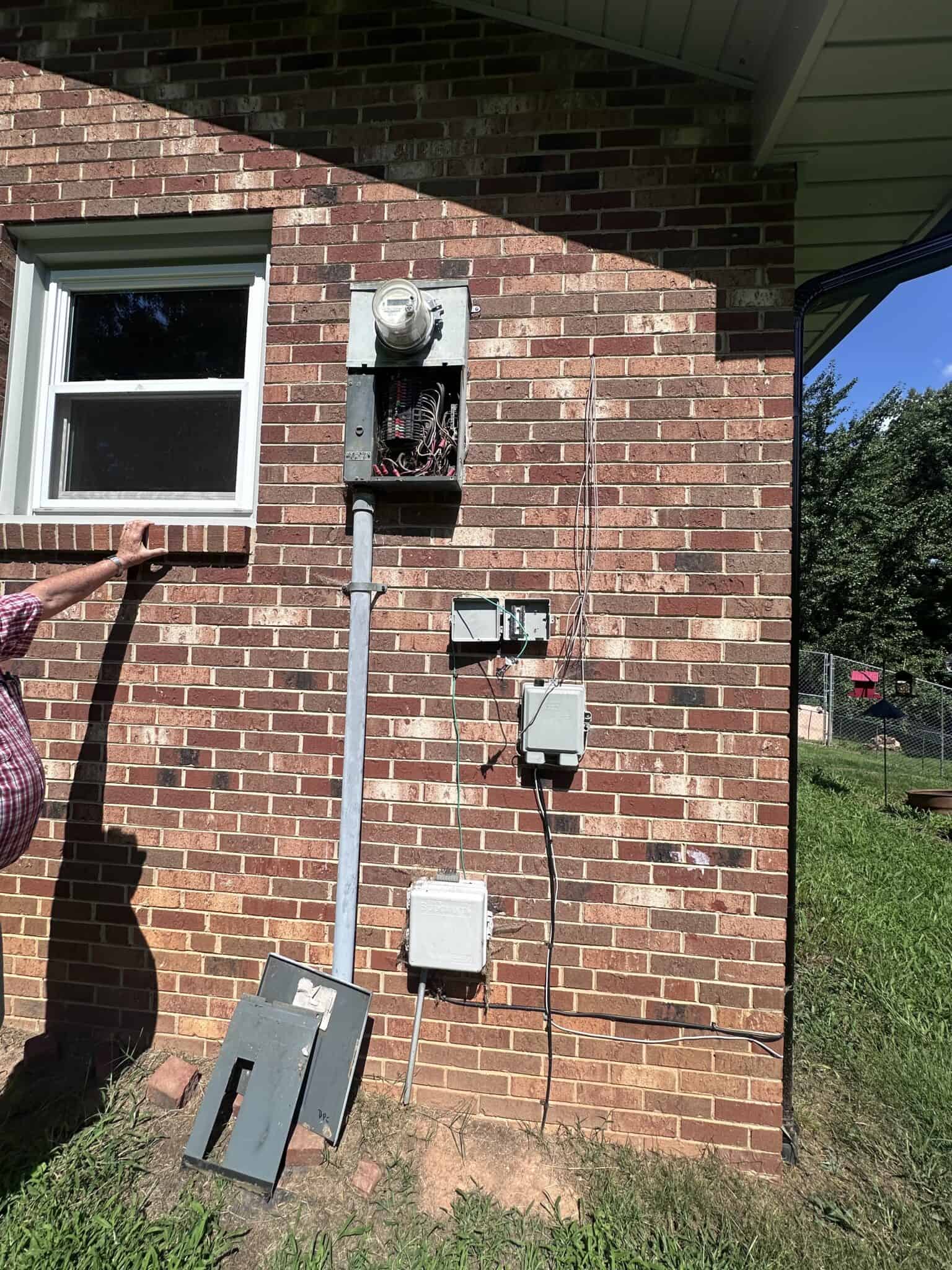 Electrical service panel on brick exterior wall.