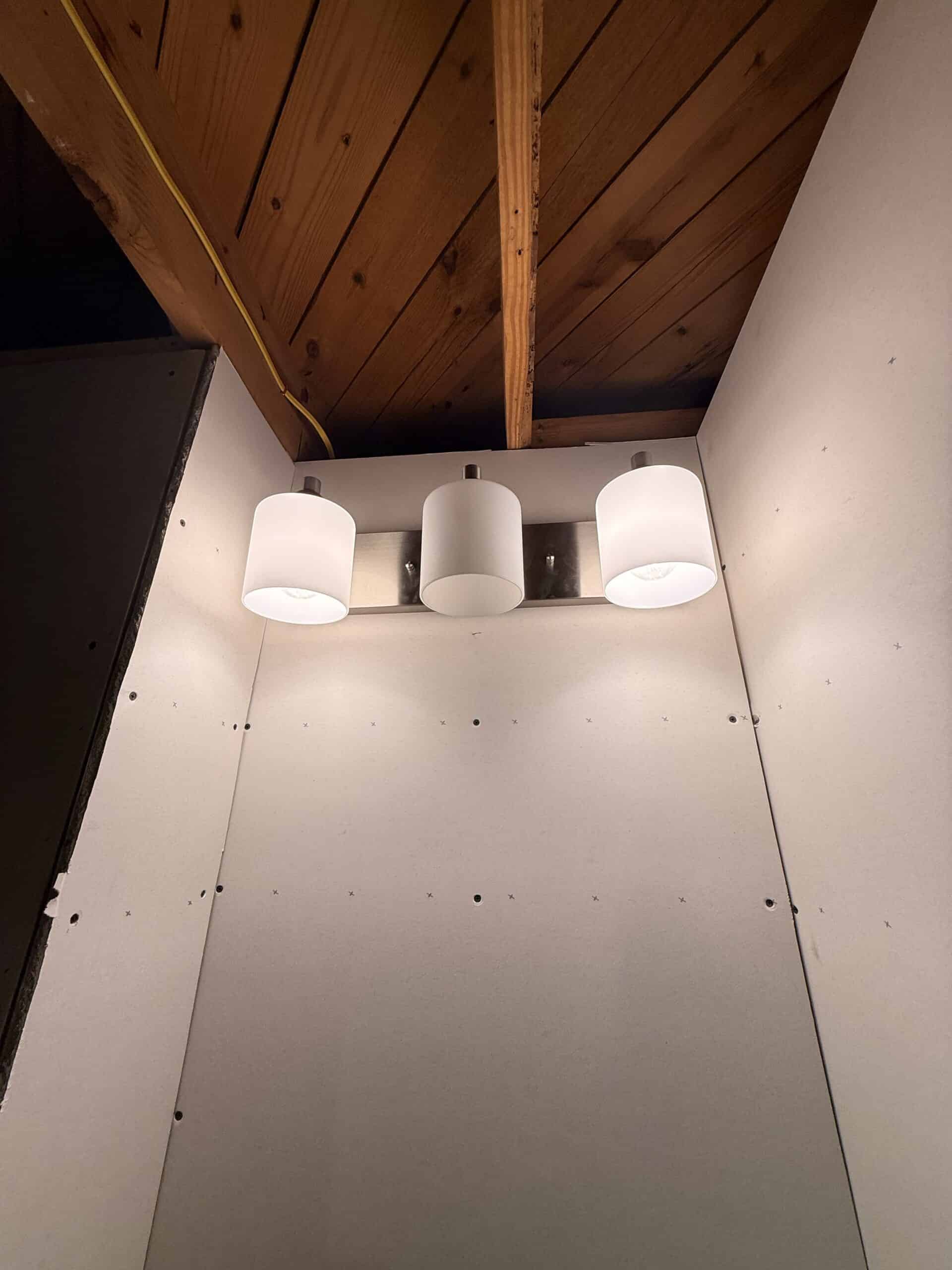 Ceiling light fixture with three white shades, ideal for home lighting.