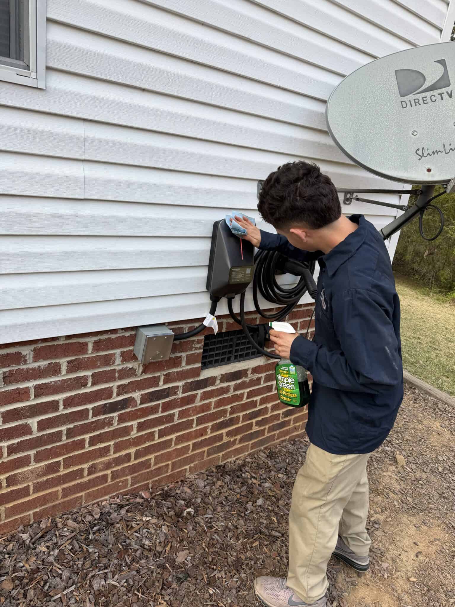 Electrical technician inspecting outdoor electrical panel.