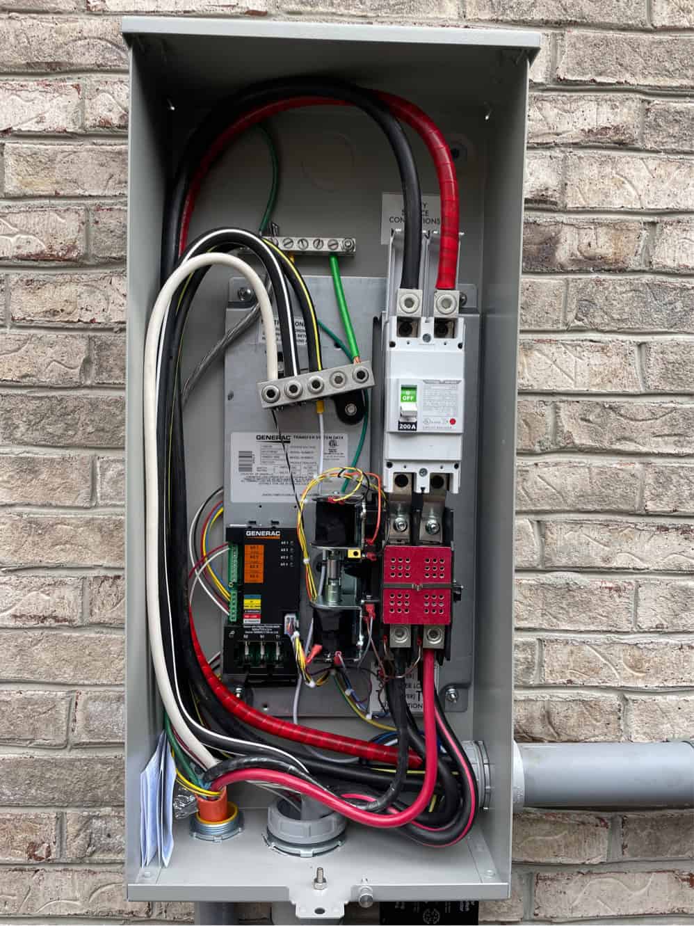 Electrical panel with generator transfer switch and wiring for home backup power system.