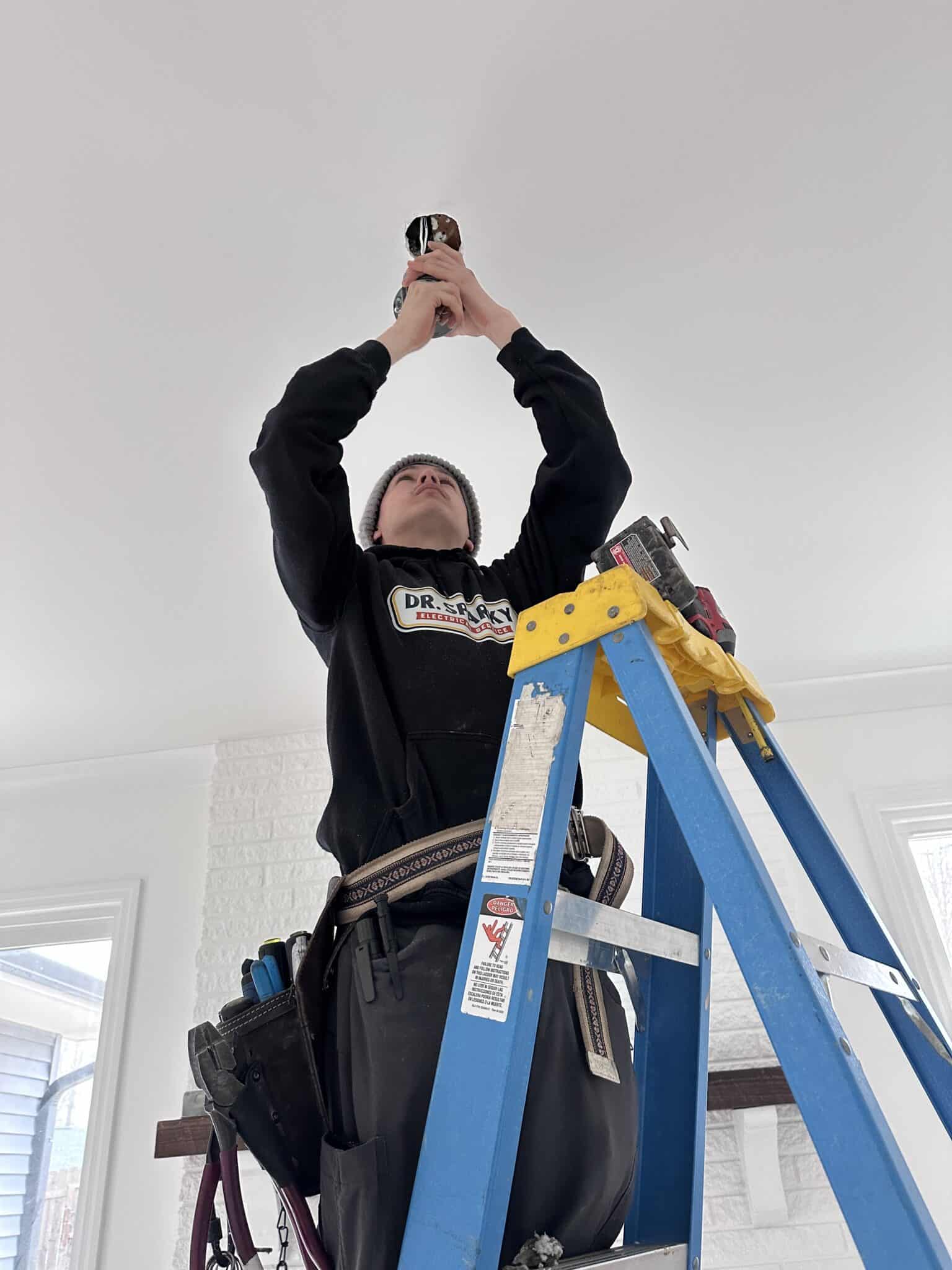 Electrical technician installing wiring in residential home.