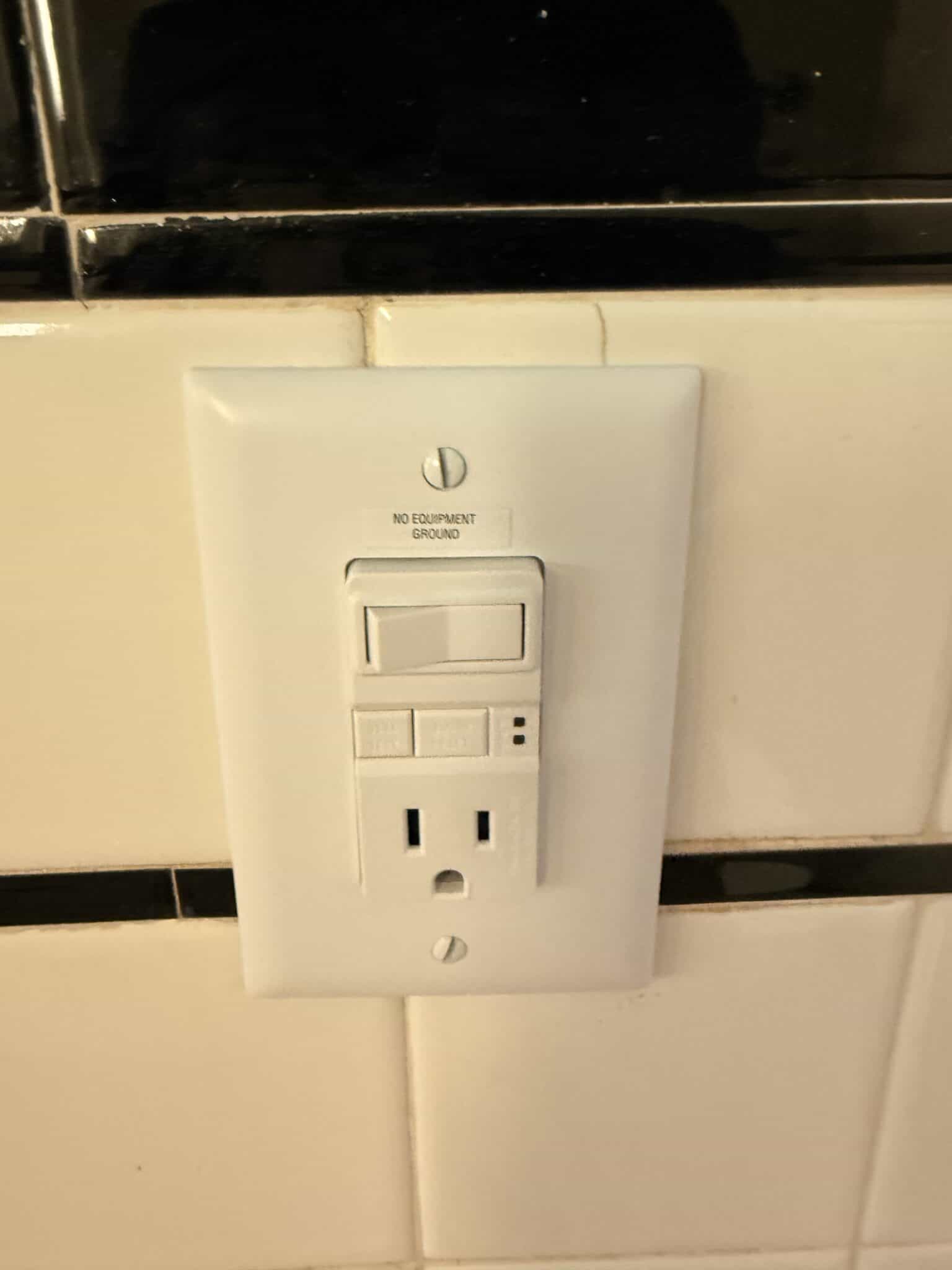 Standard electrical outlet with ground and switch in kitchen.